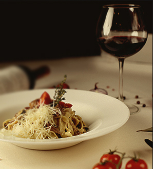 Foto de um cálice de vinho e um prato com macarrão servido